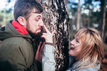 A loving guy with a girl is walking through the woods in the rain.