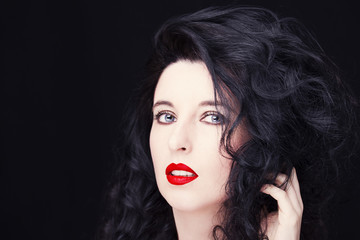Fototapeta premium Young attractive woman with long black hair on dark background.