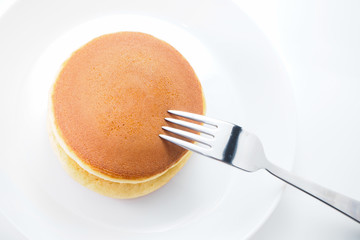 Pancakes on white disk and background with silver fork