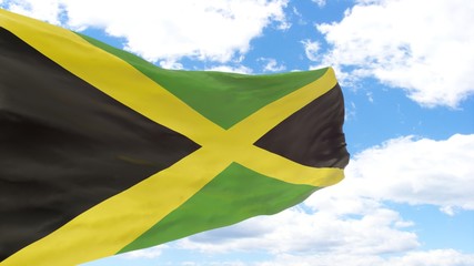 Waving flag of Jamaica on the blue cloudy sky.