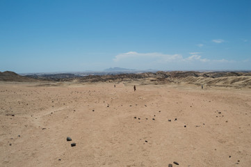 Fototapeta na wymiar Moon Landscape in Welwitschia Plains with People Walking near Swakopmund, Namibia