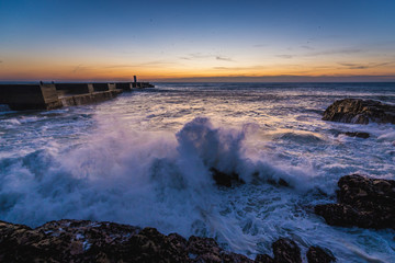 Sunset over ocean seen from breakwater in Porto, Portugal
