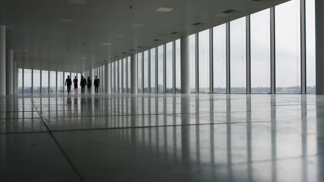 Business management team viewing empty commercial with real estate agents