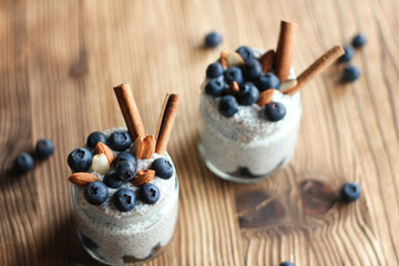 Chia pudding with blueberries and almonds in small bowls on wooden background