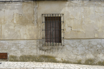 Old iron window with wooden edges on a Spanish street. Traditional architecture in spain