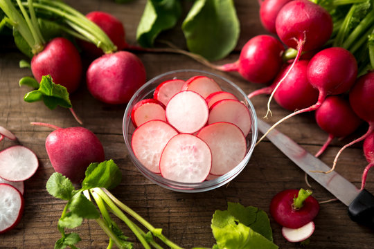 close up radish slices in the bowl and whole radishes.