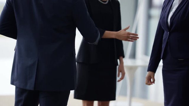  Portrait smiling businesswoman shaking hands with colleagues in modern office