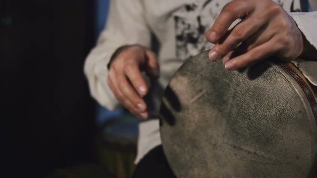 shot of man's hands drumming out a beat on an arabic percussion drum named Tombak at home.