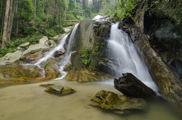 beautiful in nature, amazing cascading tropical waterfall. wet and mossy rock, surrounded by green rain forest