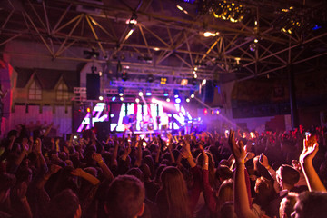 The silhouettes of concert crowd in front of bright stage lights