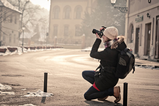 Portrait of female street photographer shooting urban scene with DSLR camera - Powered by Adobe