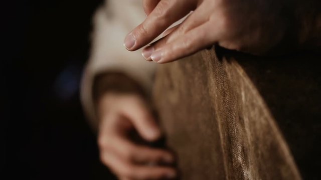extremelly close up shot of man's hands drumming out a beat on an arabic percussion drum named Bendir at home. Shot on black background