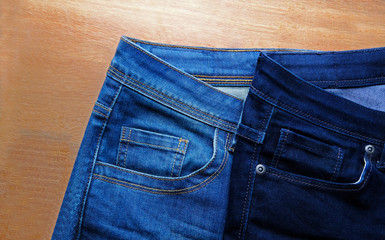 Lady's blue jeans on wooden background.