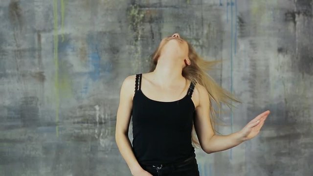 Girl teenager blonde dancing dance with her hair rotating her head.