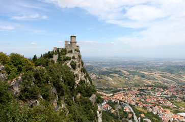 Fototapeta na wymiar San marino. Emilia-Romagna. Castle on the rock and view of town on blue sky background, horizontal view.