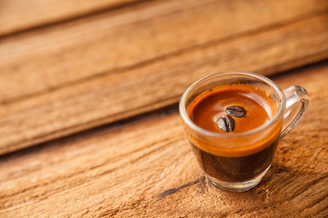 Cup of hot espresso coffee on wooden table.