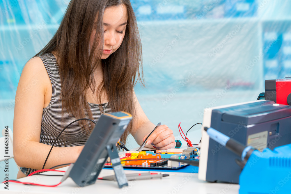 Poster Student girl in electronics laboratory, experiment with microcontroller and robot cnc module