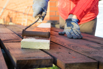 Female hand painting wood with paint roller