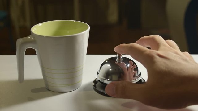 Man pushing the bell To tell the waitress to serve coffee to customers in the coffee shop