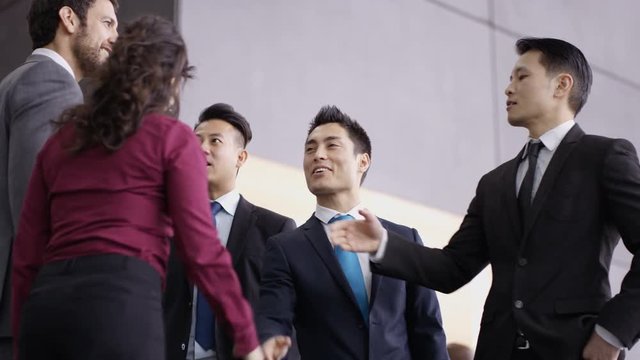  Business teams greet each other & shake hands in modern office building