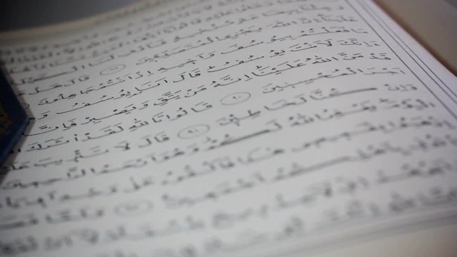 Close up shot of a copy of the Quran, Islam's holiest book, rack focus
