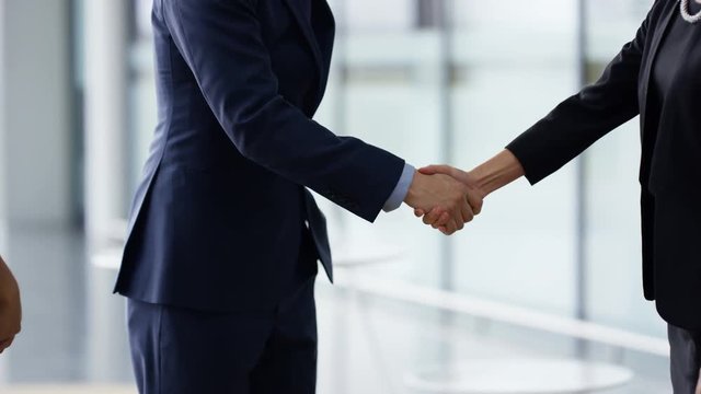  Portrait smiling businessman shaking hands with clients at end of meeting
