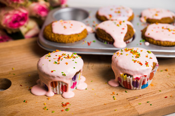 Cupcake with pink glaze on the wooden background. Selective focus.