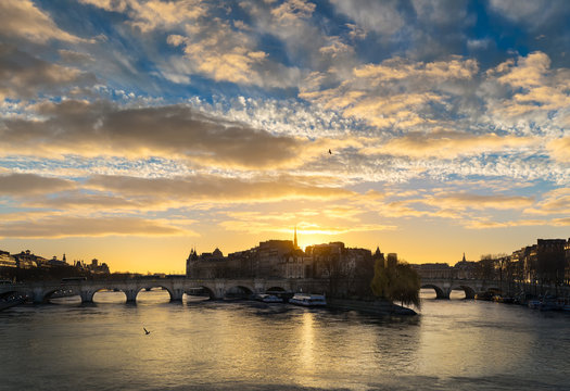 Sunrise and cloud formations over the Seine River in central Paris. The Pont Neuf links Ile de la Cite and the Left and Right Banks. France