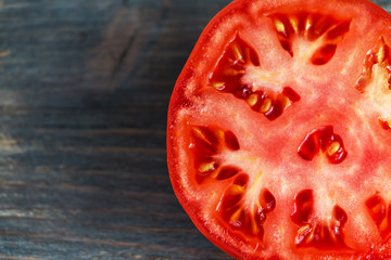 Tomato cut closeup on wooden table. Copy space.