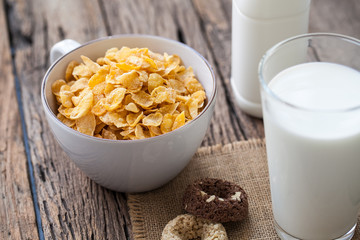 milk, cookies and bowl of cereal on wooden background
