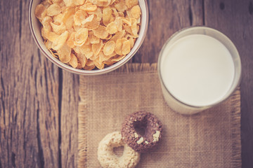 milk, cookies and bowl of cereal on wooden background