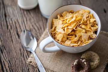 milk, cookies and bowl of cereal on wooden background