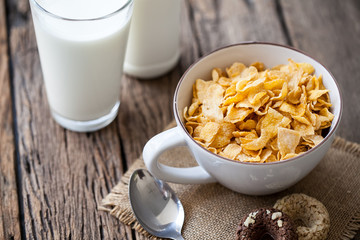 bowl of cereal and milk on wooden background