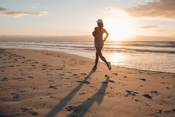 Photo sur Aluminium Jogging Young woman running on the beach