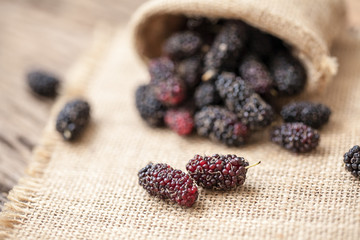 fresh organic mulberries on wooden background