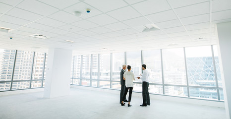 Estate agent with clients inside an empty office space