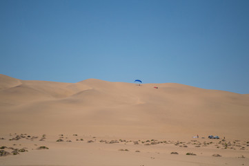 Fototapeta na wymiar Parasailing off a Sand Dune near Swakopmund, Namibia