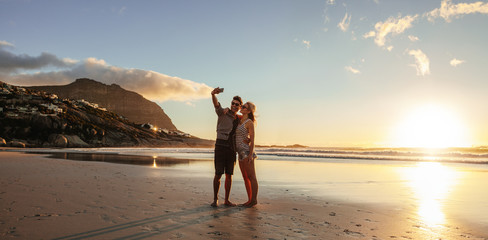 Loving young couple taking selfie at the beach - Powered by Adobe