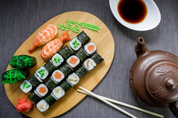 Fototapeta na wymiar Set sushi rolls, soy sauce and chopsticks on a grey tablecloth. Top view. Flat lay. Japanese food