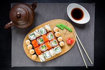 Fototapeta na wymiar Set sushi rolls, soy sauce and chopsticks on a grey tablecloth. Top view. Flat lay.