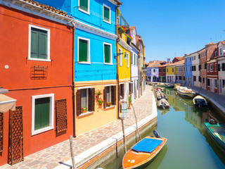 Fototapeta na wymiar Colored houses over water canal in Burano, near Venice lagoon.