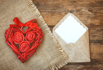 Red wicker heart with roses, ribbon, envelope