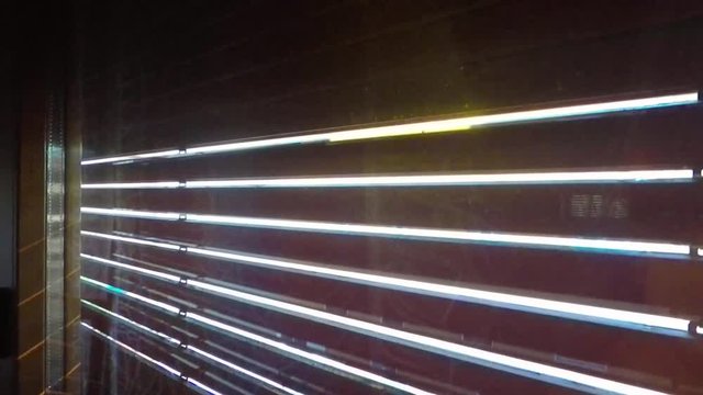 Opening a wooden rolling shutter or roller blind on a sunny day