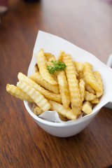 French fries in a bowl on a wooden table