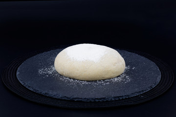 Homemade organic Dough for pizza or bread on black slate stone plate 