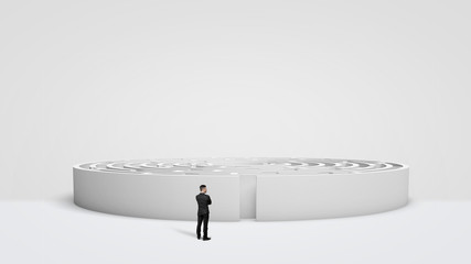 A tiny businessman standing in front of a large white round maze right next to the entrance.