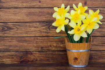 bouquet of yellow daffodils in a wooden bucket