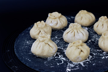 Homemade organic raw steamed Chinese bun on black slate stone plate 