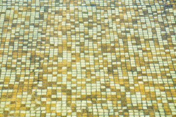 Fototapeta premium The water in the pool has a tile bottom tile glittering in the sun. Background, texture