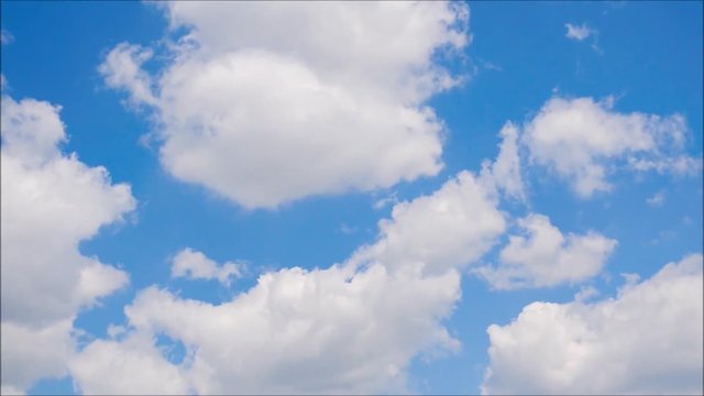 White clouds move across clear blue sky. Cloudy blue sky background.